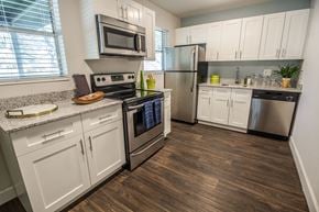 Palm Beach Gardens apartment for rent - Kitchen with white cabinets and stainless steel appliances.