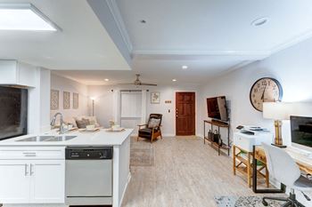 Kitchen and living room with a large clock on the wall 