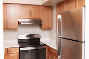 Medford apartment for rent - A modern kitchen with a stainless steel refrigerator and black stove.
