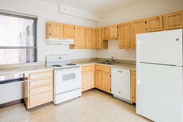 Boston apartment for rent - an empty kitchen with white appliances and wooden cabinets