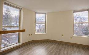Greenfield apartment for rent - an empty living room with three windows and a wood floor