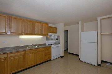 Worcester apartment for rent - A kitchen with wooden cabinets and white appliances.