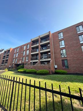 Roxbury apartment for rent - A black fence in front of a red brick building.