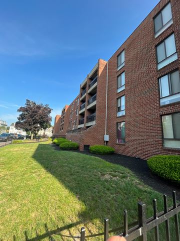 Roxbury apartment for rent - A red brick building with a green lawn in front.