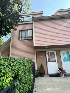 Roxbury apartment for rent - A house with a brown siding and a white door with a window above it.
