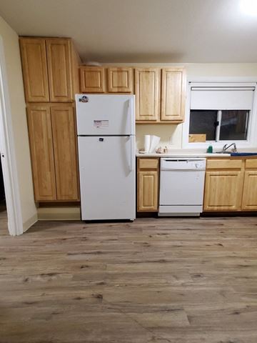 Lynn apartment for rent - a kitchen with wooden cabinets and a white refrigerator