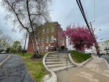 Roslindale apartment for rent - an old brick building on the corner of a street with stairs