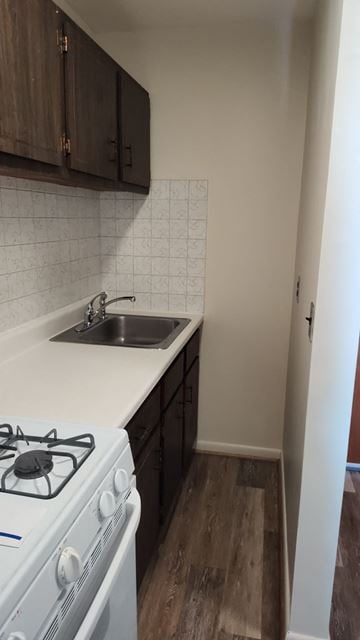 Boston apartment for rent - A white gas stove in a kitchen with wooden cabinets and a white countertop.