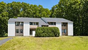 Attleboro apartment for rent - A white house with a grey roof and a green lawn in front.