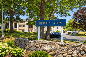 Attleboro apartment for rent - A sign that says Hillcrest Acres stands in front of a building.
