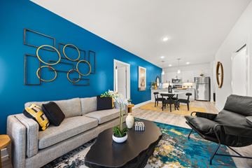 Knoxville apartment for rent - A living room with a grey sofa and a blue wall.