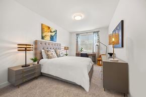 Knoxville apartment for rent - A bedroom with a white bed and a brown cabinet.