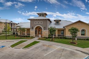 San Antonio apartment for rent - A building with a grey roof and a stone pillar entrance.