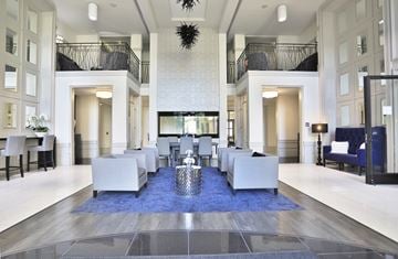 Cincinnati apartment for rent - A large, modern living room with a long white couch and a blue rug.