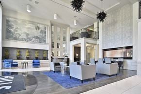 Cincinnati apartment for rent - A spacious lobby with a blue rug and white furniture.