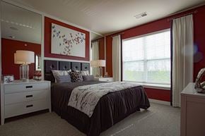 Centerville apartment for rent - A bedroom with a large bed and a painting on the wall.