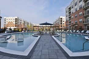 West Chester apartment for rent - A large outdoor pool surrounded by lounge chairs and umbrellas.