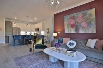 West Chester apartment for rent - A living room with a grey couch, a coffee table, and a painting on the wall.