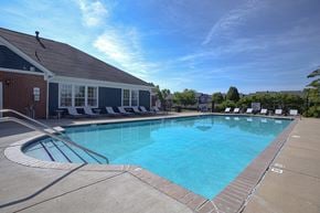 Greenwood apartment for rent - A large outdoor swimming pool with a building next to it.