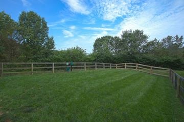 Southgate apartment for rent - A green field with a fence and trees in the background.