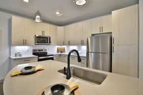 Cincinnati apartment for rent - a kitchen with white cabinets and stainless steel appliances