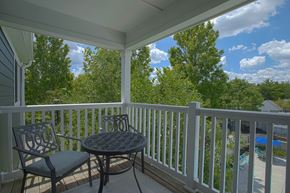 Maineville apartment for rent - A patio with a table and chairs overlooking a pool.