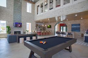 Liberty Township townhouse for rent - A pool table is in the middle of a room with a brick wall.