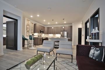 Cincinnati apartment for rent - A modern living room with a glass coffee table and a couch with a pillow on it.