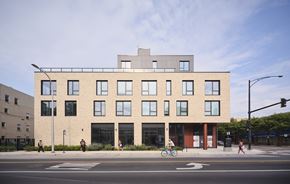 Chicago apartment for rent - A modern building with a flat roof and a balcony on the second floor.