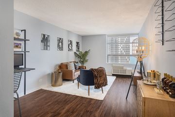 Chicago apartment for rent - A living room with a brown sofa and a black chair.