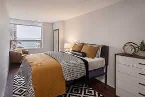 Chicago apartment for rent - A bedroom with a bed covered in a yellow and black comforter.