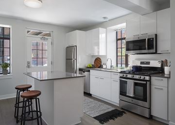 Chicago apartment for rent - A modern kitchen with white cabinets and stainless steel appliances.