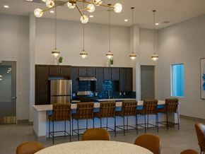 Las Vegas apartment for rent - A modern kitchen with a bar area and chairs around it.