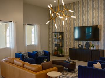 Las Vegas apartment for rent - A modern living room with blue chairs and a wooden coffee table.
