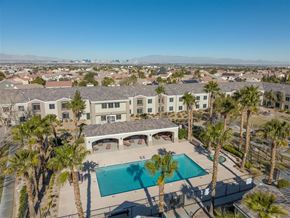 Henderson apartment for rent - A large house with a pool surrounded by palm trees.