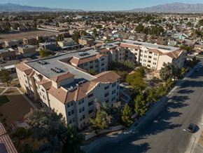Las Vegas apartment for rent - A large building with a red roof is surrounded by other buildings and trees.