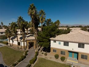 Las Vegas apartment for rent - A building with a blue door is surrounded by palm trees.