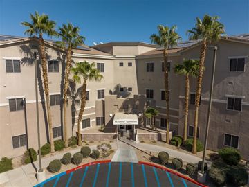 Las Vegas apartment for rent - A building with palm trees in front of it.