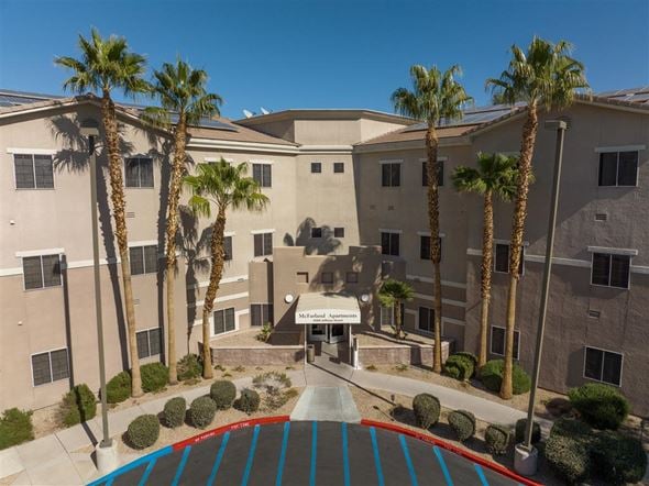 Las Vegas apartment for rent - A building with palm trees in front of it.
