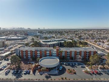 Las Vegas apartment for rent - A large building with a circular structure in front of it is surrounded by a parking lot.