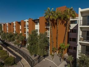 Las Vegas apartment for rent - A row of apartment buildings with palm trees in front.