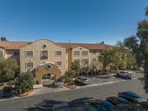 Las Vegas apartment for rent - A building with a yellow and beige facade has a blue circular window on the ground floor.