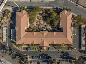 Las Vegas apartment for rent - An aerial view of a building with a red roof and a parking lot in front.