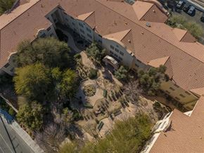 Las Vegas apartment for rent - An aerial view of a building with a red tiled roof and a courtyard with trees and bushes.