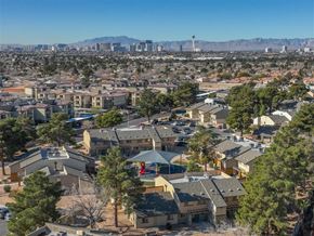 Las Vegas apartment for rent - A residential area with houses and trees in the foreground and a city skyline in the background.