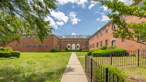 Washington apartment for rent - A long brick building with a walkway in front at Eagles Crossing Apartments, Washington DC, 20032