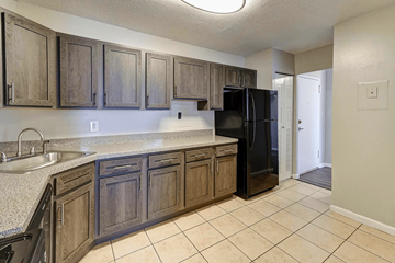 Silver Spring apartment for rent - A kitchen with wooden cabinets and a black refrigerator.
