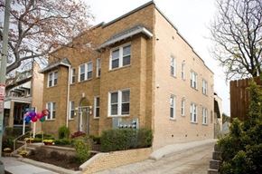 Washington apartment for rent - A brick building with a grey door and windows.