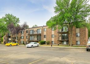 Grand Forks apartment for rent - A yellow car is parked in front of a brick building.