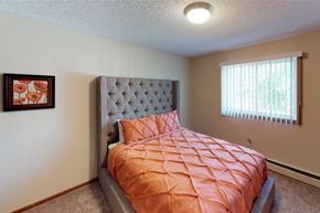 Grand Forks apartment for rent - A bedroom with a bed and a picture on the wall.